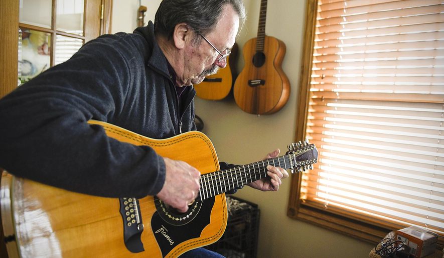 ADVANCE FOR WEEKEND EDITIONS MAY 7-8 - In this April 5, 2016 photo, Al Hams, 72, plays one of his guitars at his home in Sauk Rapids. Minn. Al Hams is 72. He has Parkinson's disease, very likely due to his exposure to the chemical defoliant Agent Orange during the year he served with the U.S. Army in Vietnam. He calls that the "missing year" a period Hams tried to forget. (Jason Wachter/St. Cloud Times via AP) NO SALES; MANDATORY CREDIT