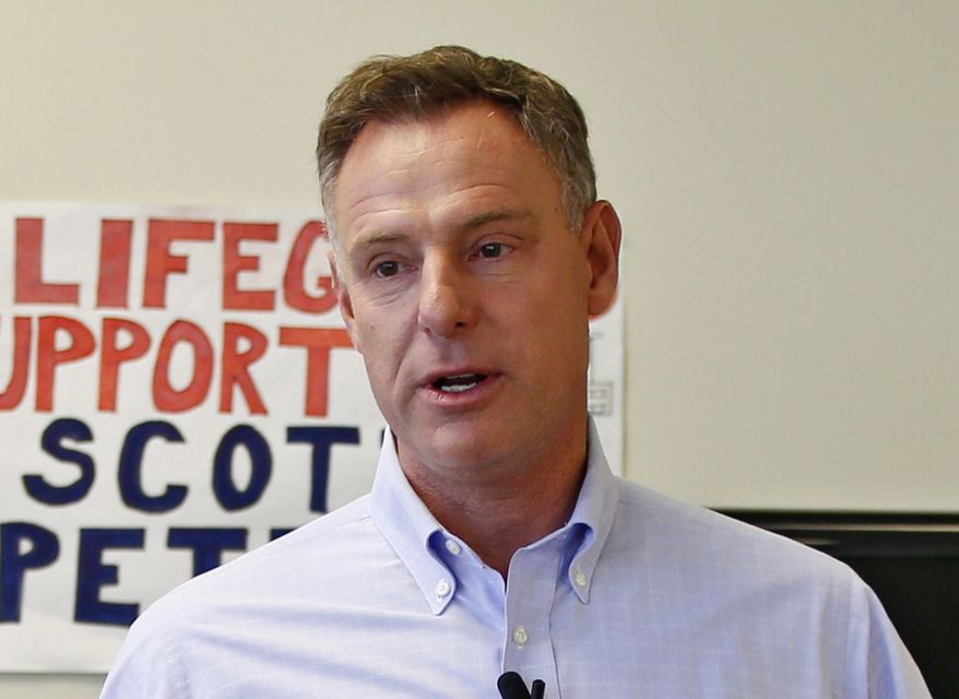 FILE - In this Nov. 3, 2014 file photo. Rep. Scott Peters, D-Calif., with his volunteers at his reelection campaign headquarters phone bank on the eve of the election in San Diego. (AP Photo/Lenny Ignelzi, File)