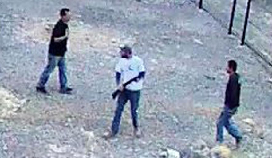 In this still image taken from security video on Saturday, April 30, 2016 and released by the National Park Service, three men inside the perimeter fence at the edge of Devils Hole in Death Valley National Park, Nev. Authorities on Monday were searching for the three men who went on a drunken binge in an environmentally fragile area of Death Valley National Park, leaving behind beer cans, shotgun shells, vomit, underwear — and possibly killing one of the rarest fishes on earth, a Devils Hole pupfish. (National Park Service via AP)
