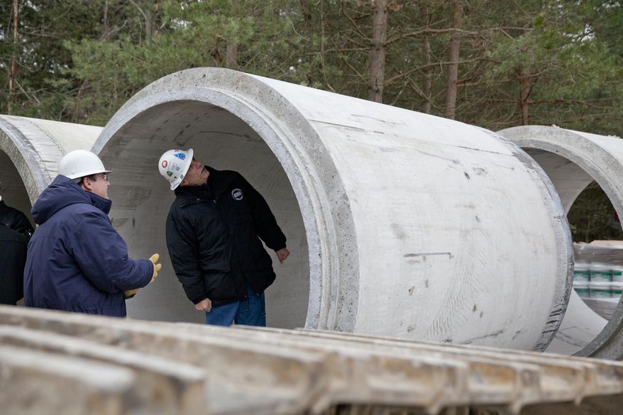 FILE - In this Nov. 26, 2013 file photo, Karegnondi Water Authority CEO Jeff Wright, right, and Deputy CEO John O'Brien look inside a pipe that will be part of the Karegnondi Pipeline Project, in Worth Township, Mich. After months of national attention on lead-tainted drinking water in Flint, many are starting to ask questions about the 74-mile pipeline being built from Lake Huron to the struggling former auto manufacturing powerhouse. (Michelle Tessier/The Flint Journal via AP, File) LOCAL TV OUT; LOCAL INTERNET OUT /The Flint Journal-MLive.com via AP) LOCAL TELEVISION OUT; LOCAL INTERNET OUT; MANDATORY CREDIT
