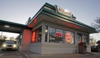 In this April 17, 2008, file photo, a customer picks up doughnuts at the drive through at a Krispy Kreme store in Matthews, N.C. (AP Photo/Chuck Burton, File) **FILE**