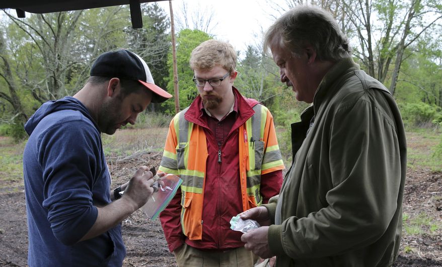 In this May 5, 2016, photo, Kevin Bradley, left, and Donald Purdon, project archeologists with Commonwealth Heritage Group, a Michigan-based firm that specializes in archaeological surveying, look at some items found by William Styple, right, at a site in Chatham, N.J. (AP Photo/Mel Evans)