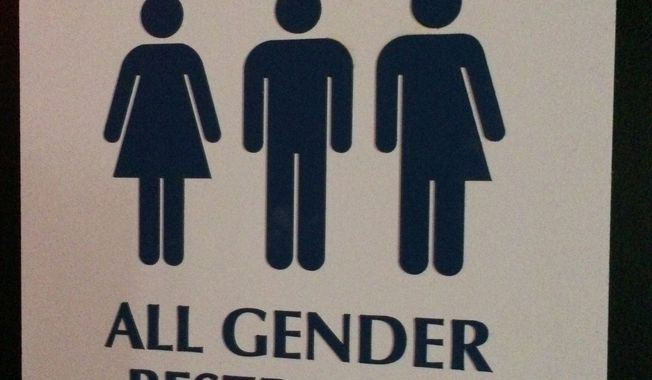 An &quot;All Gender Restroom&quot; sign hangs outside a bathroom in a bar in Washington. (Associated Press) ** FILE **