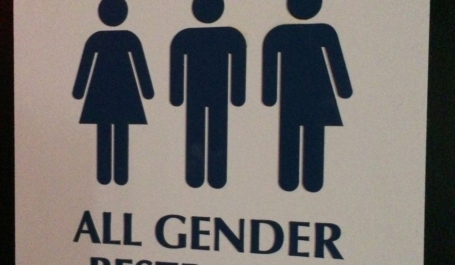 An &quot;All Gender Restroom&quot; sign hangs outside a bathroom in a bar in Washington. (Associated Press) ** FILE **