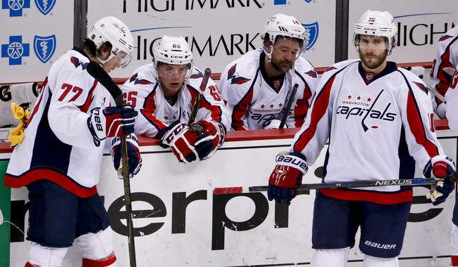 Washington Capitals&#x27; T.J. Oshie (77), Andre Burakovsky (65), Justin Williams (14) and Mike Richards (10) gather at their bench after the Capitals lost to the Pittsburgh Penguins in overtime of Game 6 of the NHL hockey Stanley Cup Eastern Conference semifinals, Tuesday, May 10, 2016 in Pittsburgh. The Penguins won 4-3 and advanced to the next round. (AP Photo/Gene J. Puskar)