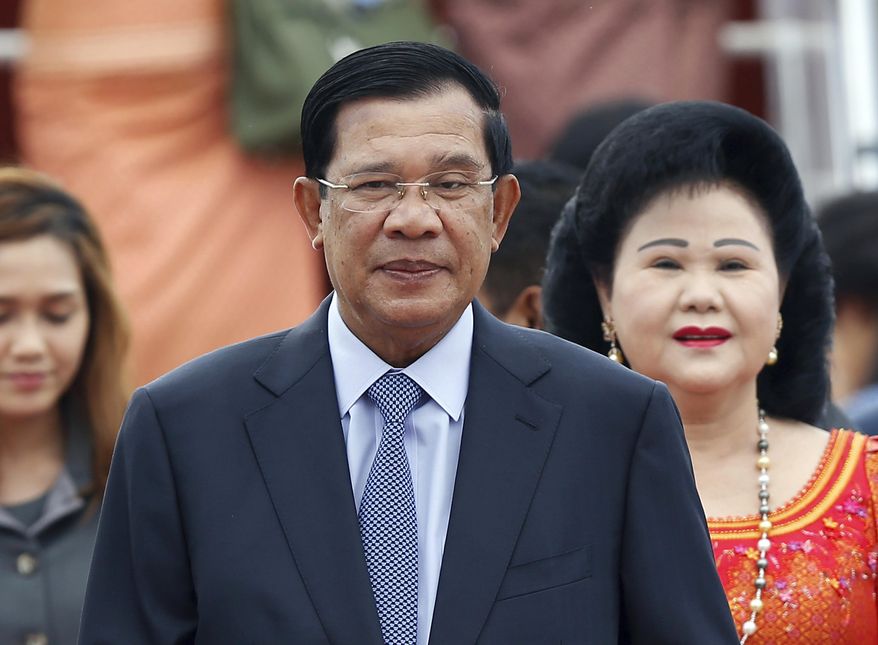 File - In this Nov. 20, 2015 file photo, Cambodia's Prime Minister Hun Sen and his wife Bun Rany arrive for the 27th Association of Southeast Asian Nations (ASEAN) summit, in Sepang, Malaysia. During a meeting between the Information Ministry and journalists Thursday, all media must use his full, honorary, six-word title "� "Samdech Akka Moha Sena Padei Techo Hun Sen" "� translates roughly to "Lord Prime Minister and Supreme Military Commander" - in the opening lines of print articles, radio and TV stories about the leader starting in August. (AP Photo/Lai Seng Sin, File)