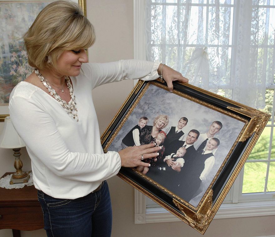 ADVANCE FOR USE SATURDAY, MAY 14 AND THEREAFTER - In this March 13, 2016 photo, Donna Brent, of LeRoy, Ill., looks over a photograph of her family, including her husband who died of stomach cancer, and her six children who are now grown. After having successful colon cancer surgery, Brent has become an advocate for people age 50 and older to get a colonoscopy to check for colon cancer and polyps that can be removed before they turn into cancer. (Lori Ann Cook-Neisler/The Pantagraph via AP) MANDATORY CREDIT