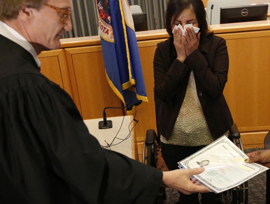 ADVANCE FOR USE MONDAY, MAY 16 - In this photo taken, Monday, May 9, 2016, Zahra Zamiri, of Rochester, Minn., wipes away tears after giving the "Oath of Allegiance" during her naturalization ceremony at the Olmsted County Government Center in Rochester, Minn. Zamiri, a native of Iran and resident of Rochester, is now the newest U.S. citizen. (Andrew Link/The Rochester Post-Bulletin via AP) MANDATORY CREDIT