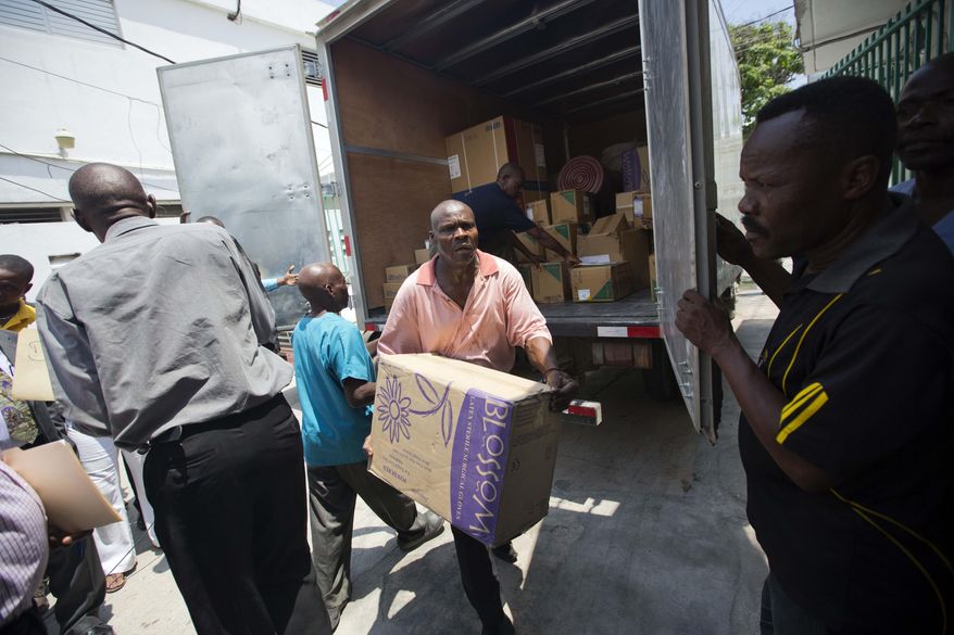 A worker deliver boxes of gloves to the General Hospital in Port-au-Prince, Haiti, Thursday, May 12, 2016. Doctors have refused to take new patients since late March, saying the government isn't providing supplies or compensating them fairly. A truckload of basic medical supplies has been delivered but resident doctors say it's not nearly enough to end their weeks-old strike. (AP Photo/Dieu Nalio Chery)
