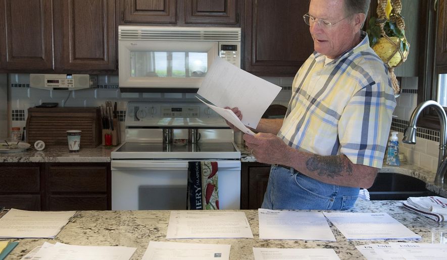 In this photo taken Monday, May 9, 2016, Chuck Zellers, of Lincoln, Neb., looks through some of the records and paperwork he has accumulated while trying to fix a Social Security error that declared him deceased. (Gwyneth Roberts/The Journal-Star via AP) LOCAL TELEVISION OUT; KOLN-TV OUT; KGIN-TV OUT; KLKN-TV OUT; MANDATORY CREDIT