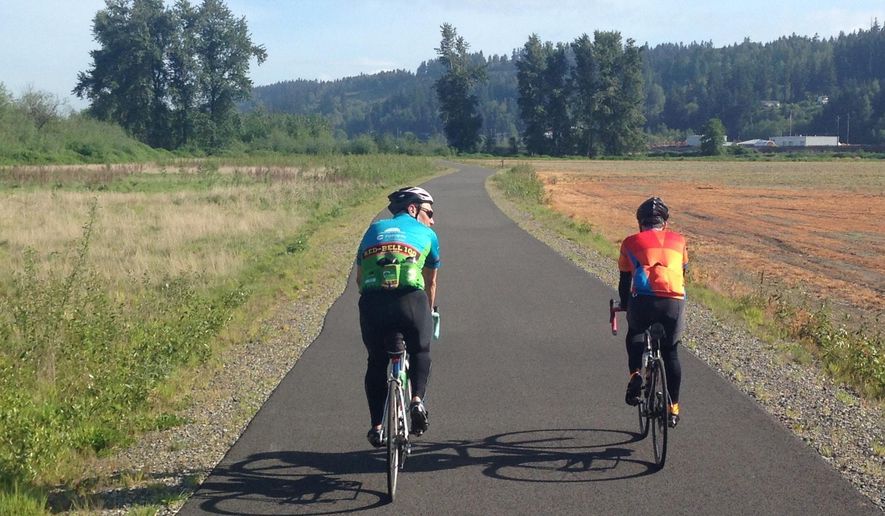 ADVANCE FOR USE SATURDAY, MAY 14 - In this photo taken April 30, 2016,Rick Beitelspacher, left, and Russ Meyers roll along the Sumner Link Trail near Sumner, Wash. The trail allows cyclists to easily link to other multi-use trails in the South Puget Sound area. (Craig Hill/The News Tribune via AP) MANDATORY CREDIT