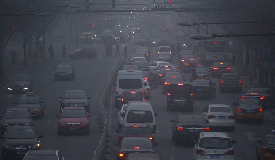 FILE - In this Dec. 25, 2015, file photo, pedestrians make their way across a busy intersection on a day with severe air pollution in Beijing. The World Health Organization on Thursday May 12, 2016 released new information from its Global Urban Ambient Air Pollution Database, that says 98 percent of residents in large cities of low- and middle-income countries are facing excessively high air pollution. (AP Photo/Mark Schiefelbein, File)