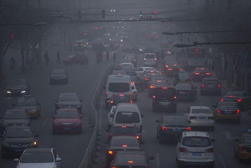 FILE - In this Dec. 25, 2015, file photo, pedestrians make their way across a busy intersection on a day with severe air pollution in Beijing. The World Health Organization on Thursday May 12, 2016 released new information from its Global Urban Ambient Air Pollution Database, that says 98 percent of residents in large cities of low- and middle-income countries are facing excessively high air pollution. (AP Photo/Mark Schiefelbein, File)