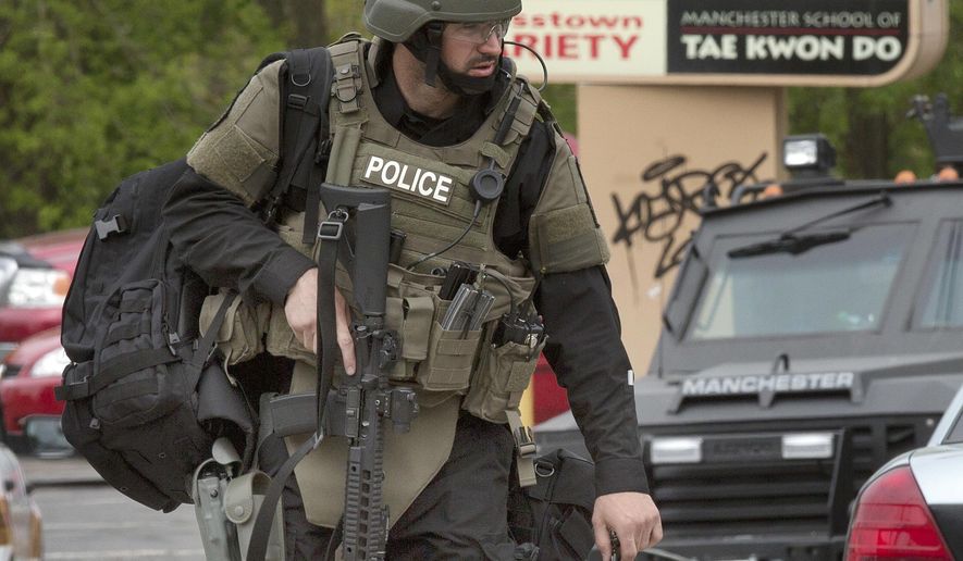 A police officer works the scene Friday, May 13, 2016, in Manchester, N.H., after two police officers were shot overnight. No immediate details on the shootings were available. (AP Photo/Jim Cole)