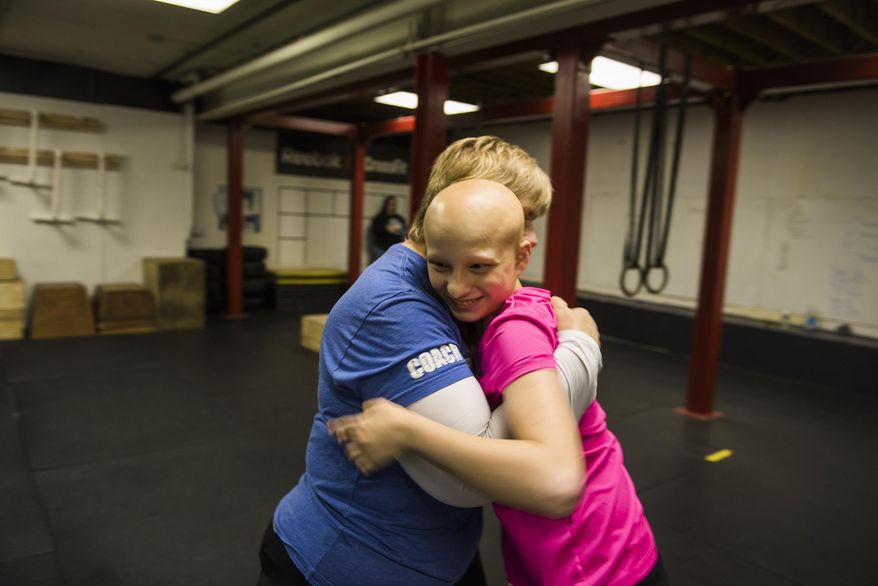 ADVANCE FOR SATURDAYMAY 14 AND THEREAFTER - In a Feb. 17, 2016 photo, Katie Krotz, 17, gives a hug to her Crossfit instructor, Sheron Smith, while attending a session of Smith's "Special Warriors" Crossfit program at Hanover Crossfit in Hanover, Pa. The program is designed for children with autism or other learning disabilities by keeping them active. Smith has also developed a close bond with Krotz. (Shane Dunlap/The Evening Sun via AP) MANDATORY CREDIT