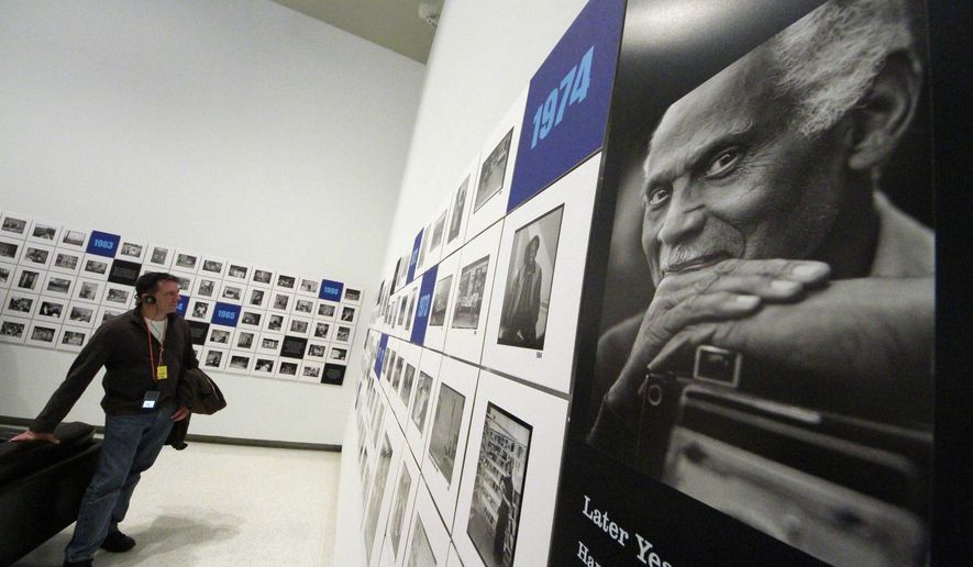 FILE - In this Nov. 1, 2011, file photo, a museum visitor views works by late Pittsburgh photographer Charles "Teenie" Harris, known for documenting daily African-American life, in an exhibit at the Carnegie Museum of Art in Pittsburgh. In May 2016, 24-year-old Dominique Luster began work as the archivist for the museum's Charles "Teenie" Harris Archive, an endowed position seeded with $300,000 from the National Endowment for the Humanities plus $900,000 from local foundations and individual donors. (AP Photo/Gene J. Puskar, File)