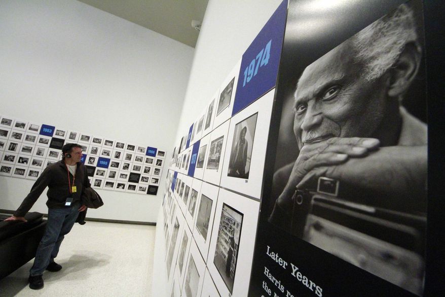 FILE - In this Nov. 1, 2011, file photo, a museum visitor views works by late Pittsburgh photographer Charles "Teenie" Harris, known for documenting daily African-American life, in an exhibit at the Carnegie Museum of Art in Pittsburgh. In May 2016, 24-year-old Dominique Luster began work as the archivist for the museum's Charles "Teenie" Harris Archive, an endowed position seeded with $300,000 from the National Endowment for the Humanities plus $900,000 from local foundations and individual donors. (AP Photo/Gene J. Puskar, File)