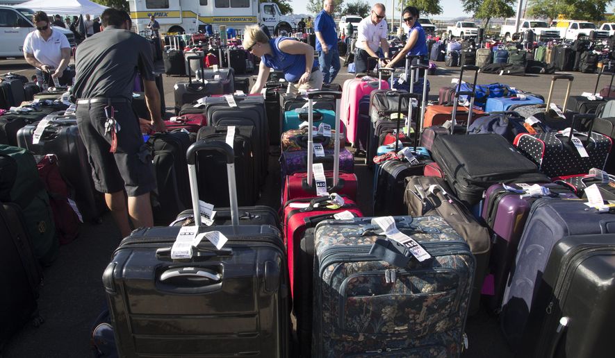 Baggage sits in the special events parking lot, Thursday, May 12, 2016, at Phoenix Sky Harbor International Airport. More than 3,000 checked bags missed their outbound flights in Phoenix because of a problem with a screening system at Sky Harbor International Airport, officials with Transportation Security Administration said. (Mark Henle/The Republic via AP) MARICOPA COUNTY OUT, NO SALES