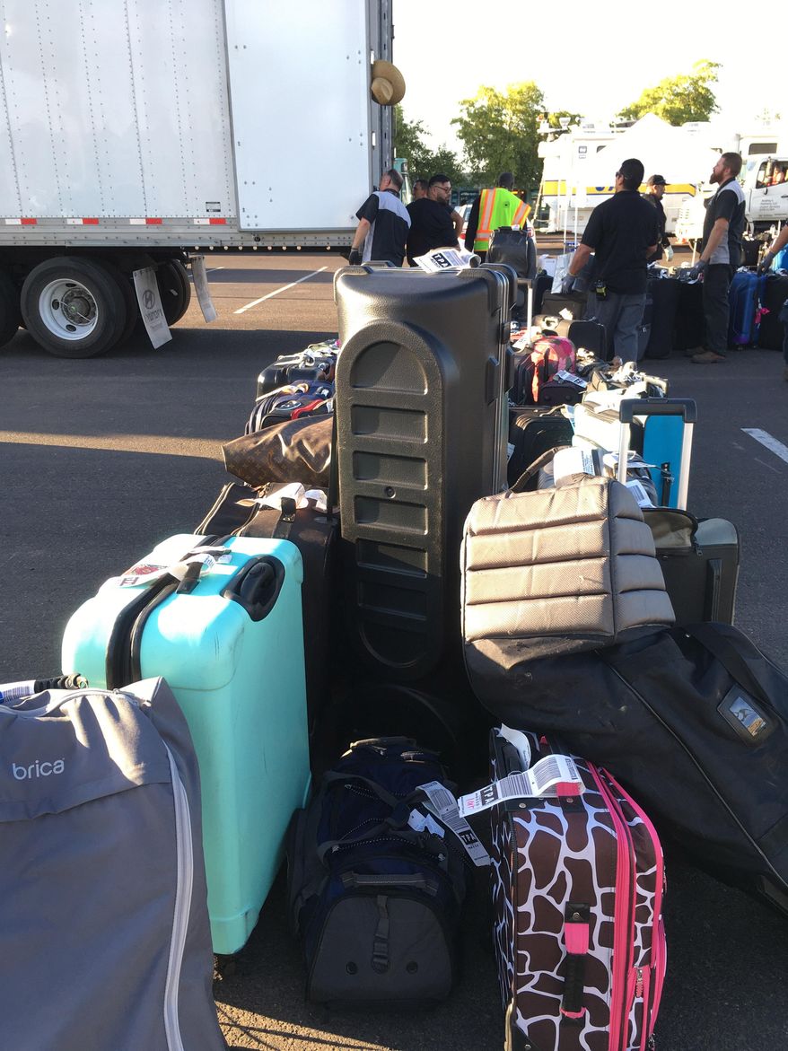 In this Thursday, May 12, 2016 photo workers put passenger luggage on a semi truck at Sky Harbor International Airport in Phoenix. More than 3,000 checked bags missed their outbound flights in Phoenix because of a problem with a screening system at The airport officials with Transportation Security Administration said. (AP Photo/Anna Johnson)