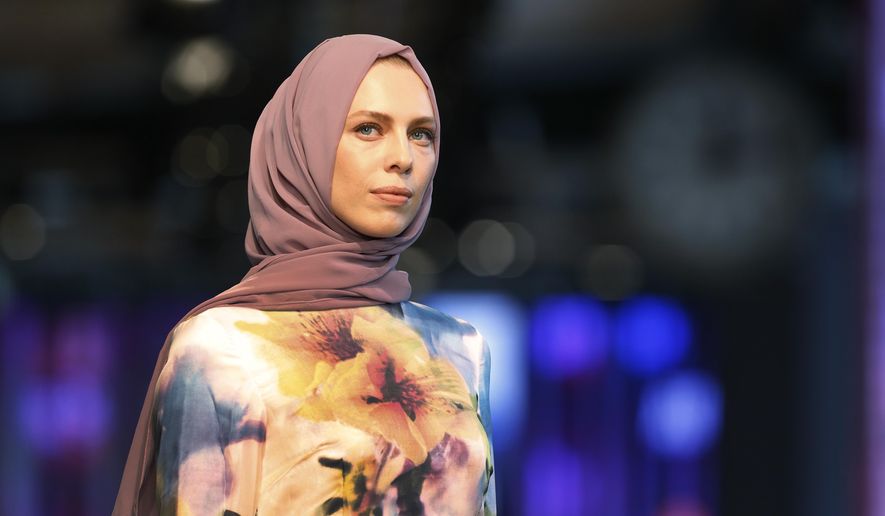A model hits the catwalk of a fashion show during the International Modest Fashion Week, in Istanbul, Friday, May, 13, 2016. Turkey’s first International Modest Fashion Week has opened in Istanbul bringing designers and models of conservative wear from around the world. The two-day event kicked off Friday with models hitting the runway at a historic train station donning a bright palette of breezy garment and kaleidoscopic headscarves. (AP Photo/Lefteris Pitarakis)