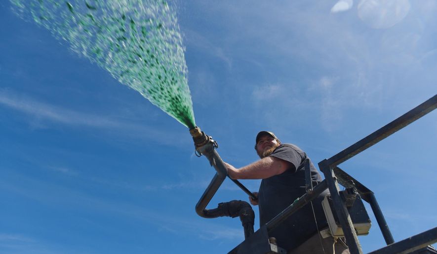 In this Wednesday, May 4, 2016, Sam Herbert, of Rainforest Hydroseeding, sprays a hydroseeding mix at the new west side addition to the Provo City Cemetery, in Utah. The Provo cemetery’s new addition offers a mix of the old-style monument options with more modern and convenient spaces with unusual styling new to the cemetery. (Spenser Heaps/The Daily Herald via AP) MANDATORY CREDITWED., MAY 4, 2016 PHOTO.