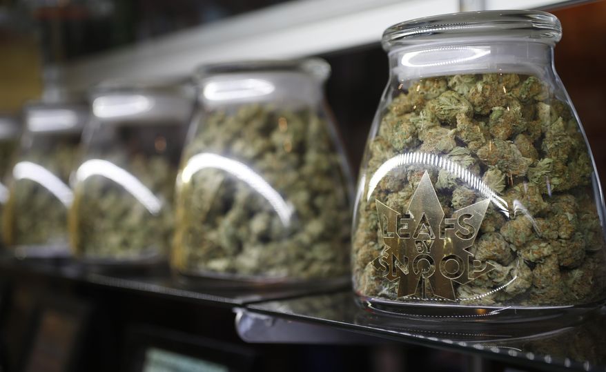 In this Friday, Dec.18, 2015, file photograph, the logo is shown on the front of jars of marijuana buds marketed by rapper Snopp Dogg in one of the LivWell marijuana chain&#39;s outlets south of downtown Denver. (AP Photo/David Zalubowski, file)