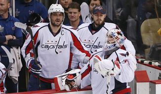 Washington Capitals goalie Braden Holtby (70) stands with teammates Alex Ovechkin (8) and Philipp Grubauer, center, as the Pittsburgh Penguins celebrate a 4-3 overtime win during Game 6 of the NHL hockey Stanley Cup Eastern Conference semifinals, Tuesday, May 10, 2016 in Pittsburgh. (AP Photo/Gene J. Puskar)