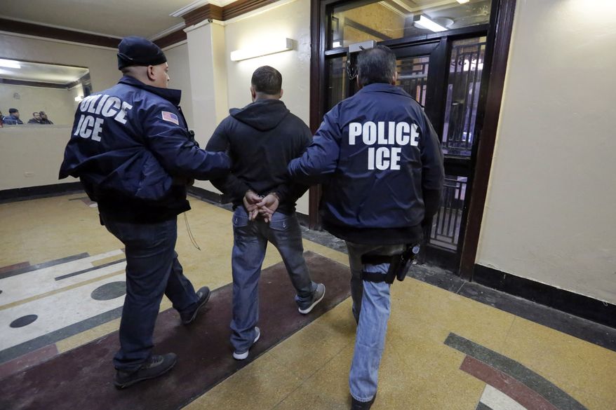 Immigration and Customs Enforcement officers escort an arrestee during a series of early-morning raids on March 3, 2015, in the Bronx borough of New York. (Associated Press) **FILE**