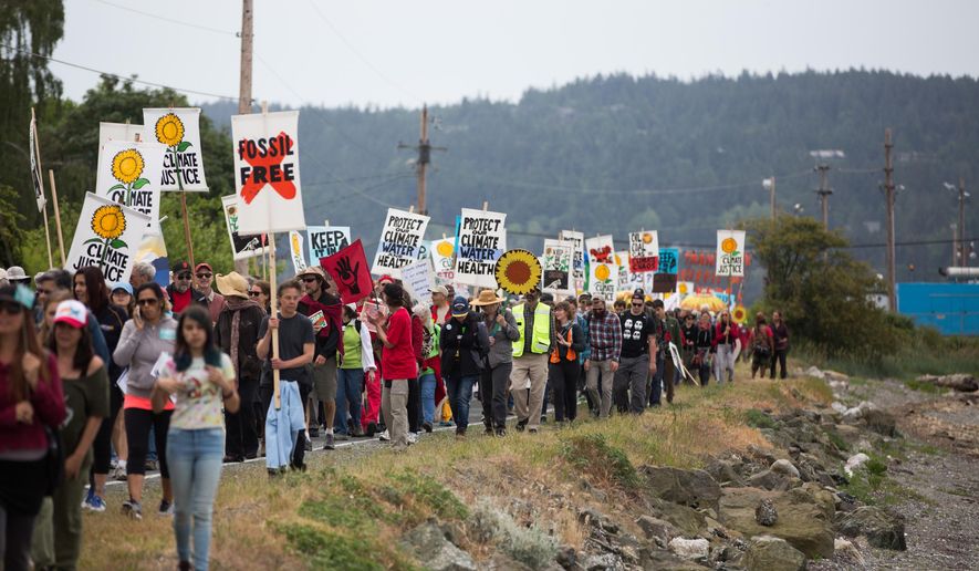 Protesters march towards the tip of March Point during the Break Free PNW Indigenous Day of Action near the oil refineries in Anacortes, Wash., on Saturday, May 14, 2016. The protests are part of a series of global actions calling on people to "break free" from dependence on fossil fuels. (Grant Hindsley/seattlepi.com via AP)