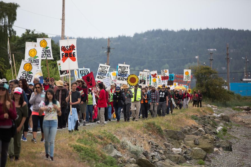 Protesters march towards the tip of March Point during the Break Free PNW Indigenous Day of Action near the oil refineries in Anacortes, Wash., on Saturday, May 14, 2016. The protests are part of a series of global actions calling on people to "break free" from dependence on fossil fuels. (Grant Hindsley/seattlepi.com via AP)