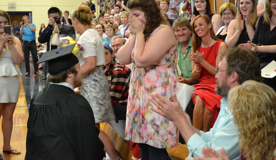 In a Saturday, May 14, 2016 photo provided by the University of Maine at Presque Isle, University of Maine at Presque Isle's Timothy Babine proposes to his girlfirend, Hayley Hamilton, during commencement exercises at the school. Hamilton shook her head "yes," and Babine placed an engagement ring on her finger. The crowd cheered. (Rachel Rice/University of Maine at Presque Isle via AP)