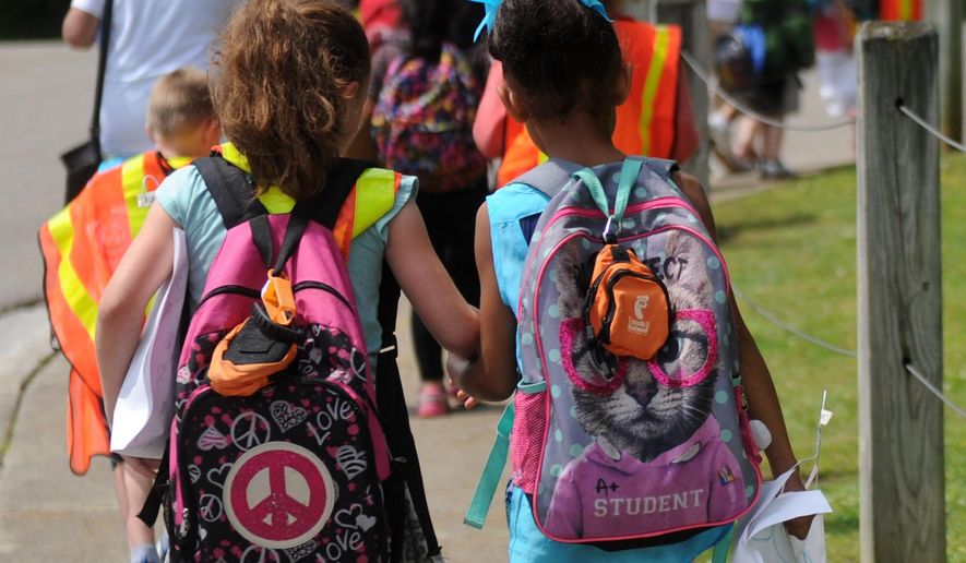 In this photo taken Wednesday, May 11, 2016, Christenberry Elementary School students take part in the Walking School Bus program in Knoxville, Tenn. The program helps children after school to walk safely to their guardians while also providing exercise. (Caitie McMekin/Knoxville News Sentinel, via AP)
