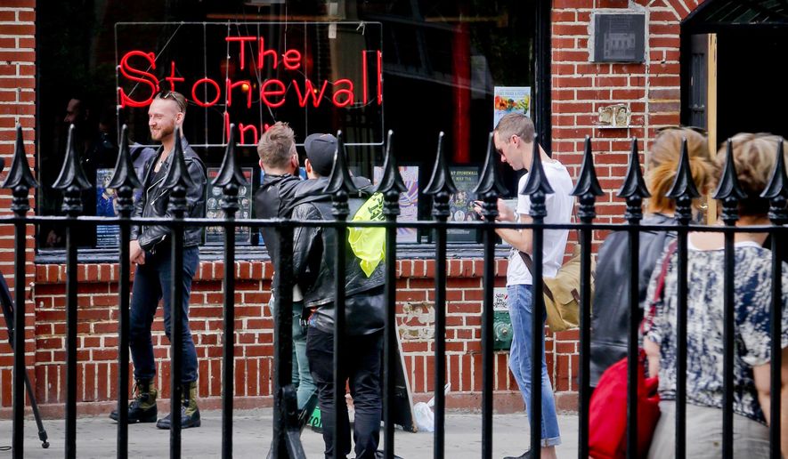 In this May 9, 2016 photo, visitors gather outside the Stonewall Inn, the iconic symbol of the modern gay rights movement across from Christopher Park, in New York. The area surrounding the Stonewall Inn, the site of a 1969 uprising widely viewed as the start of the fight for LGBT rights, is set to become a national monument. But that doesn’t mean the bar will always be a bar. (AP Photo/Bebeto Matthews)