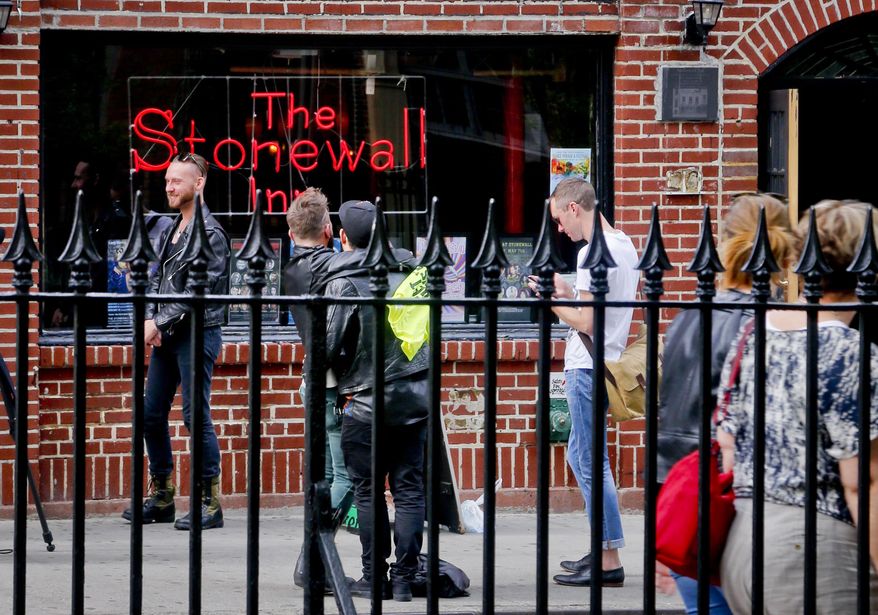 In this May 9, 2016 photo, visitors gather outside the Stonewall Inn, the iconic symbol of the modern gay rights movement across from Christopher Park, in New York. The area surrounding the Stonewall Inn, the site of a 1969 uprising widely viewed as the start of the fight for LGBT rights, is set to become a national monument. But that doesn’t mean the bar will always be a bar. (AP Photo/Bebeto Matthews)