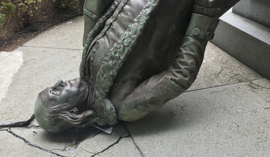 In this photo released by the City of Boston Mayor's office, a statue of Benjamin Franklin lies on the concrete outside where it landed when knocked off its pedestal outside Old City Hall in Monday, May 16, 2016, in Boston. A spokesperson for the mayor said high winds pushed a nearby tent into the statue, causing it to fall off its pedestal. (City of Boston via AP)