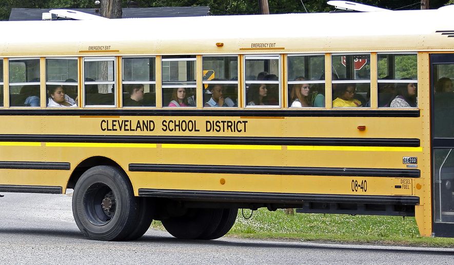 FILE- In this May 13, 2015 file photograph, an integrated group of Cleveland, Miss., public school students ride the school district bus on their way home following classes. A federal judge ruled on a desegregation case, Friday, May 13, 2016, that the Cleveland school district must merge its high schools and middle schools to achieve racial desegregation. (AP Photo/Rogelio V. Solis, File)