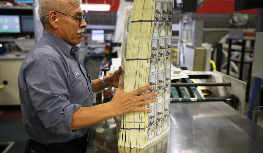 In a Wednesday, April 20, 2016 photo, Juan Reyna uses a machine that vibrates to aerate a stack of $100 notes before a digital inspection at the Bureau of Engraving and Printing in Fort Worth, Texas. This helps keep the machine from getting a paper jam during the inspection process. (Vernon Bryant/The Dallas Morning News via AP)