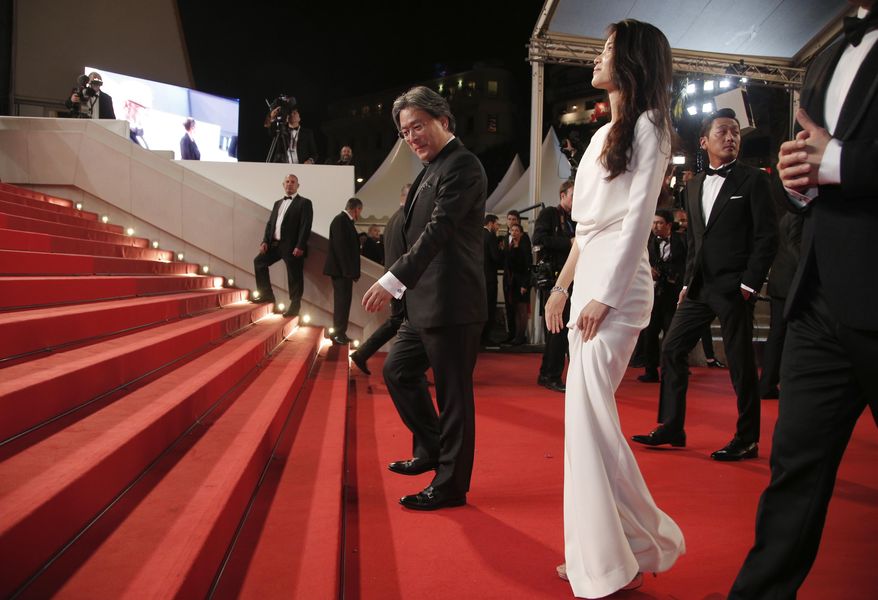 Director Park Chan-Wook, centre and actress Kim Tae-Ri pose for photographers upon arrival at the screening of the film The Handmaiden at the 69th international film festival, Cannes, southern France, Saturday, May 14, 2016. (AP Photo/Thibault Camus)