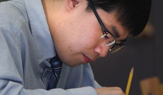 ADVANCE FOR USE SATURDAY, MAY 21, 2016, AND THEREAFTER- In this May 9, 2016, photo, Simon Zhang works on a test during one of his classes in Hyannis, Mass. Zhang is a senior who is in his second year at Pope John Paul and is one of four elected members of student council. (Steve Haines/The Cape Cod Times via AP)  MANDATORY CREDIT; MAGS OUT; NO SALES; TV OUT