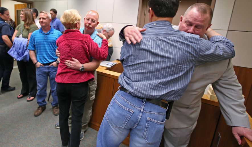 Victims' family, friends, and law enforcement, including Village Public Safety Officer Mark Haglin, right, console each other after guilty verdicts were handed down to Nathanial Kangas for two counts of murder in the first degree in Superior Court Judge Paul Lyle's courtroom at the Rabinowitz Courthouse on Monday, May 16, 2016, in Fairbanks, Alaska. A Fairbanks jury deliberated six hours before convicting Kangas, 22, in the deaths of Sgt. Scott Johnson and Trooper Gabe Rich in May 2014, the Fairbanks Daily News-Miner reported. The officers were shot at Kangas' home in the village of Tanana, about 130 miles west of Fairbanks, as they attempted to arrest Kangas' father. (Eric Engman/Fairbanks Daily News-Miner via AP) MANDATORY CREDIT