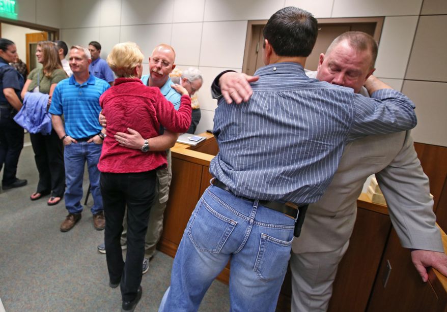 Victims' family, friends, and law enforcement, including Village Public Safety Officer Mark Haglin, right, console each other after guilty verdicts were handed down to Nathanial Kangas for two counts of murder in the first degree in Superior Court Judge Paul Lyle's courtroom at the Rabinowitz Courthouse on Monday, May 16, 2016, in Fairbanks, Alaska. A Fairbanks jury deliberated six hours before convicting Kangas, 22, in the deaths of Sgt. Scott Johnson and Trooper Gabe Rich in May 2014, the Fairbanks Daily News-Miner reported. The officers were shot at Kangas' home in the village of Tanana, about 130 miles west of Fairbanks, as they attempted to arrest Kangas' father. (Eric Engman/Fairbanks Daily News-Miner via AP) MANDATORY CREDIT