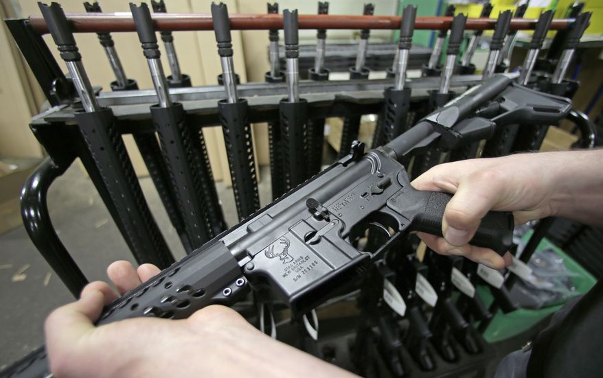 In this April 10, 2013 file photo, craftsman Veetek Witkowski holds a newly assembled AR-15 rifle at the Stag Arms company in New Britain, Conn, Wednesday, April 10, 2013. (AP Photo/Charles Krupa) ** FILE **
