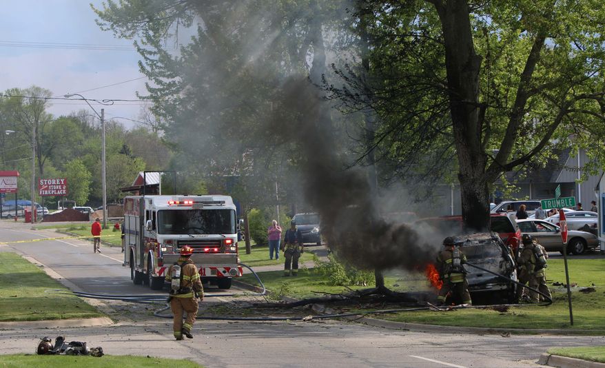 First responders work on the scene of a car crash on Francis St. in Jackson, Mich., on Monday, May 16, 2016. Authorities say a driver who sped away from a traffic stop in southern Michigan has died after losing control of the SUV he was driving and crashing into a tree. (Taylor Irby/Jackson Citizen Patriot-Mlive Media Group via AP)