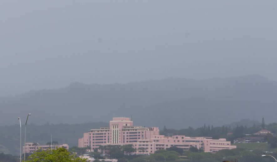 FILE - This May 2, 2014 file photo shows the Tripler Army Medical Center, where Sgt. Michael Walker has been assigned since 2013, shrouded in rain clouds in Honolulu. The Army medic charged with conspiring with his lover to kill his wife in Hawaii will be court-martialed for child pornography and prostitution charges that surfaced while investigating the killing. Walker's general court-martial is set for June 20 and June 21 at Wheeler Army Airfield on Oahu, said Jim Guzior, spokesman for Tripler Army Medical Center. A pretrial hearing is scheduled for next week. (AP Photo/Marco Garcia, File)