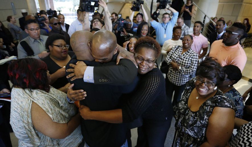 John Nolley, center facing camera, hugs his brother LaMarcus Nolley as his sister Mia Nolley hugs them following John Nolley's release from prison, at the 213th District Court, in Fort Worth Texas. Nolley, who had been found guilty of murder in 1998, was released from custody after almost 19 years behind bars due to new evidence. Nolley's mother Alice Samuel stands at right. (Paul Moseley /Star-Telegram via AP) MAGS OUT; (FORT WORTH WEEKLY, 360 WEST); INTERNET OUT; MANDATORY CREDIT
