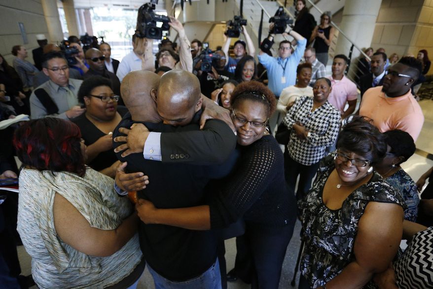 John Nolley, center facing camera, hugs his brother LaMarcus Nolley as his sister Mia Nolley hugs them following John Nolley's release from prison, at the 213th District Court, in Fort Worth Texas. Nolley, who had been found guilty of murder in 1998, was released from custody after almost 19 years behind bars due to new evidence. Nolley's mother Alice Samuel stands at right. (Paul Moseley /Star-Telegram via AP) MAGS OUT; (FORT WORTH WEEKLY, 360 WEST); INTERNET OUT; MANDATORY CREDIT