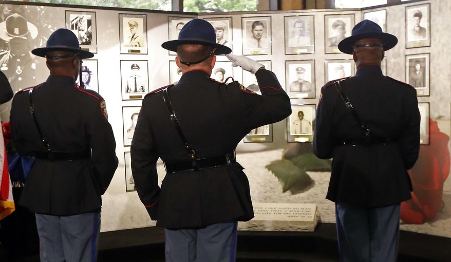 A Mississippi Highway Patrol honor guard stands at attention in front of the Mississippi Department of Public Safety memorial wall at headquarters in Jackson, Miss., during the 2016 Fallen Officers Memorial Service, Tuesday, May 17, 2016. Gov. Phil Bryant, a former sheriff's deputy, addressed the survivors, relatives and friends of those state highway patrolmen and members of the Mississippi Bureau of Narcotics who have been killed in the line of duty. Law enforcement departments and agencies statewide are holding similar memorial ceremonies to honor those local lawmen who were killed in the line of duty. (AP Photo/Rogelio V. Solis)