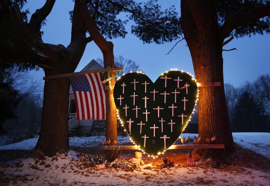 In this Dec. 14, 2013 file photo, a makeshift memorial with crosses for the victims of the Sandy Hook Elementary School shooting massacre stands outside a home in Newtown, Conn., on the one-year anniversary of the shootings. With sweeping views of Newtown's rolling hills, a field at the town's highest point emerged early on as the first choice for planners of a permanent memorial to honor the 26 people killed at Sandy Hook Elementary School. Open space advocates, however, objected to construction on the pristine area known as the High Meadow. As more community members have spoken out, the planning commission, which includes parents of the some of the massacre victims, agreed recently to go back and consider other options. (AP Photo/Robert F. Bukaty, File)