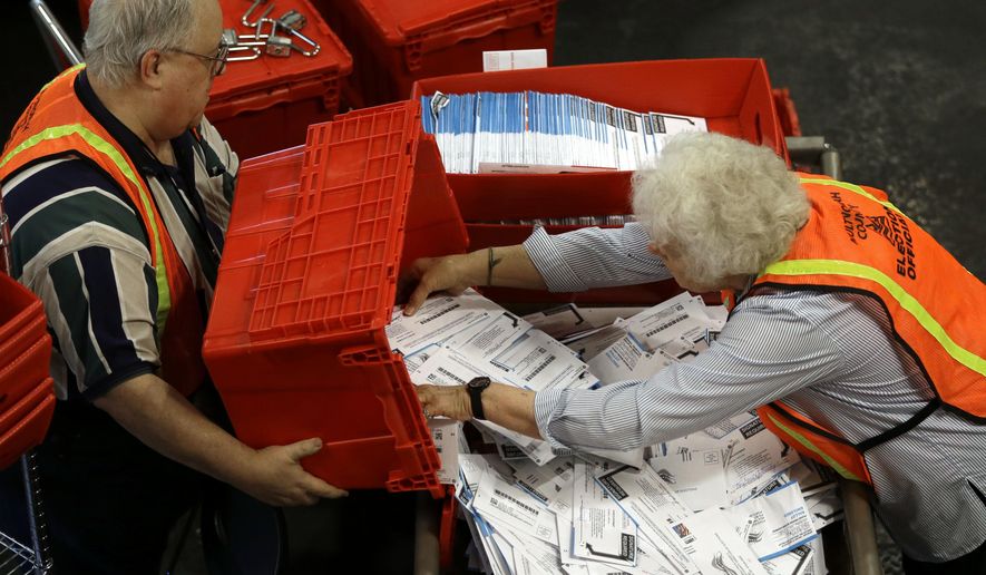 Election workers Louise Masog, right, and John Jones prepare ballots for counting at Multnomah County election headquarters in Portland, Ore., Tuesday, May 17, 2016. Tuesday is Oregon's primary election. (AP Photo/Don Ryan)