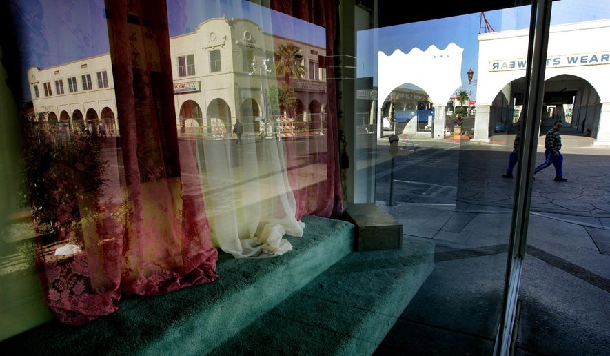 FILE - This April 15, 2010 file photo, a storefront window sits empty as downtown Calexico, Calif. is reflected in the glass. The U.S. Justice Department issued a scathing review Wednesday, May 18, 2016, of the small town's police practices in a big drug and immigrant smuggling corridor on California's border with Mexico, finding a lack of basic controls and oversight of criminal investigations, unstable leadership and other red flags. (AP Photo/Sandy Huffaker,File)